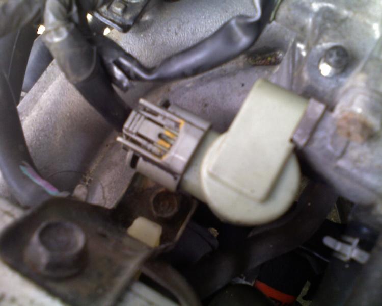How do you locate the IAT sensor plug on a vehicle?